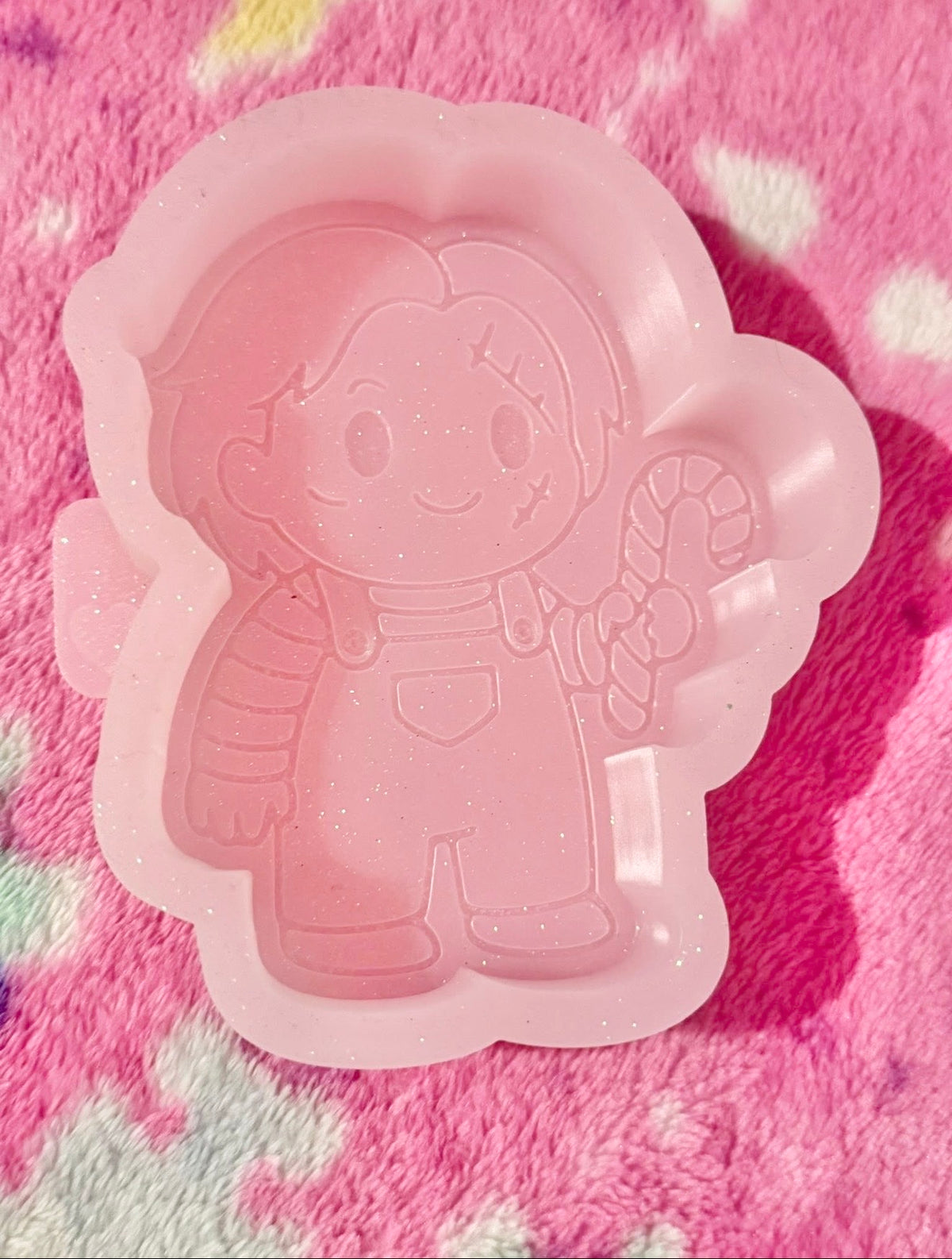 Chucky holding a candy cane mold